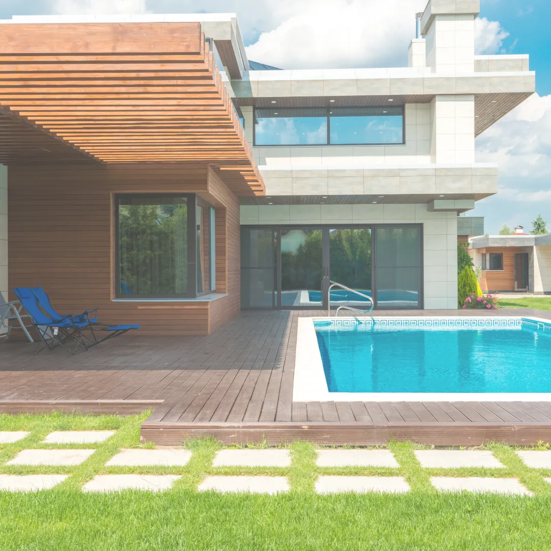 Μοντέρνα εξοχική κατοικία με ξύλινο deck, πισίνα και πέργκολα, παράδειγμα ολιστικού βιοκλιματικού σχεδιασμού.