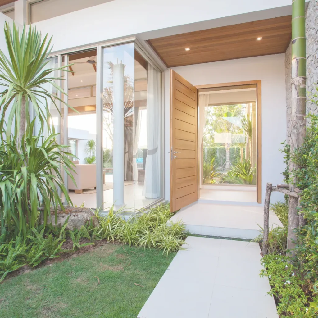 Είσοδος σύγχρονου σπιτιού με μεγάλα κουφώματα, όπου η ενεργειακή αναβάθμιση με σωστά τζάμια είναι κρίσιμη για την καλοκαιρινή άνεση.