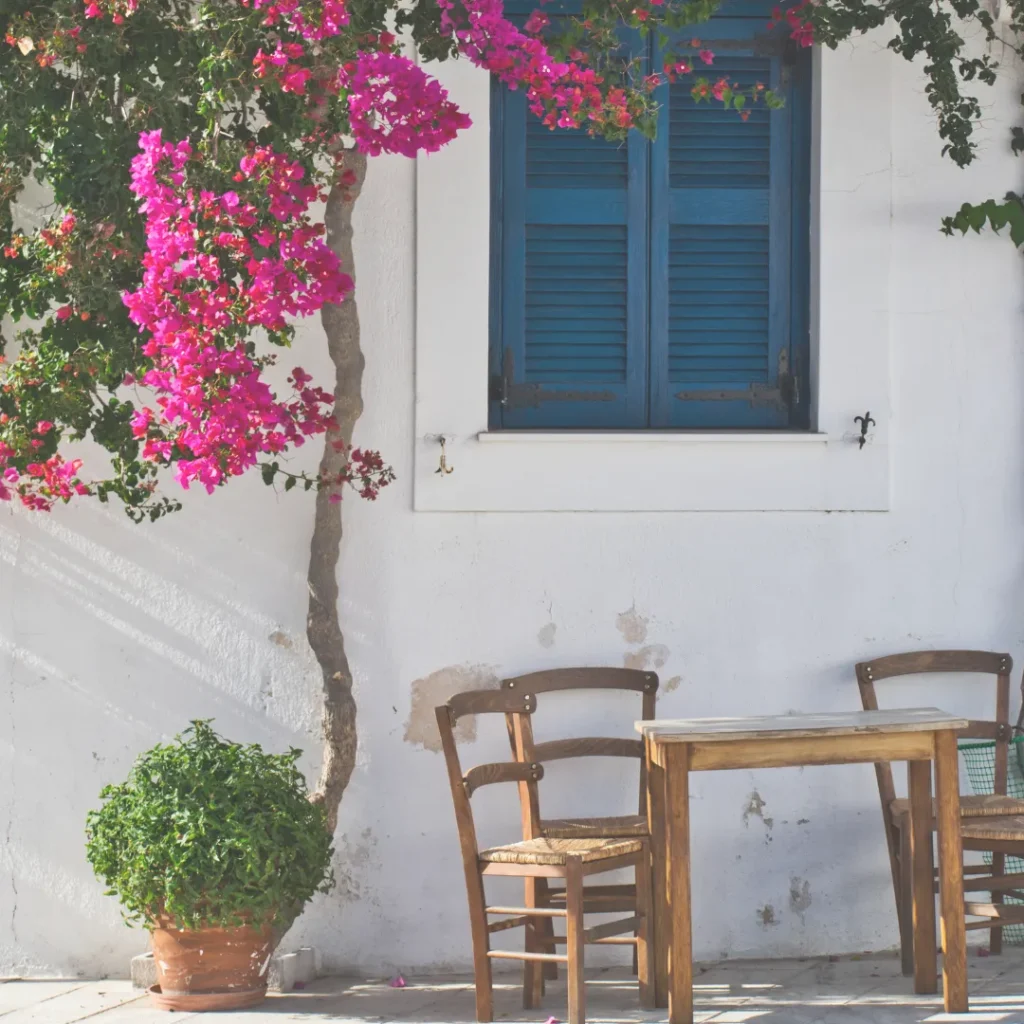 Ιδέες για καλοκαιρινή διακόσμηση διαμερίσματος και Airbnb με φυσικά υλικά, όπως ξύλινες καρέκλες και λευκούς τοίχους.