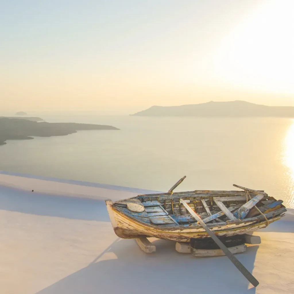 Έμπνευση για καλοκαιρινή διακόσμηση σπιτιού: παλιά ξύλινη βάρκα σε ταράτσα με θέα το ηλιοβασίλεμα στο Αιγαίο.