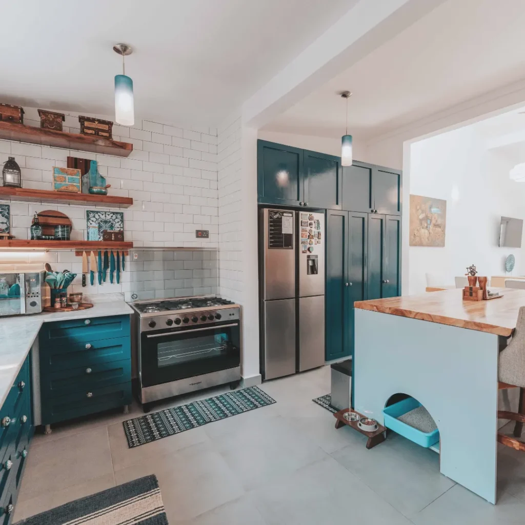 Μοντέρνα κουζίνα με πετρόλ ντουλάπια, ξύλινη νησίδα και ζεστό φωτισμό που αποπνέει θαλπωρή