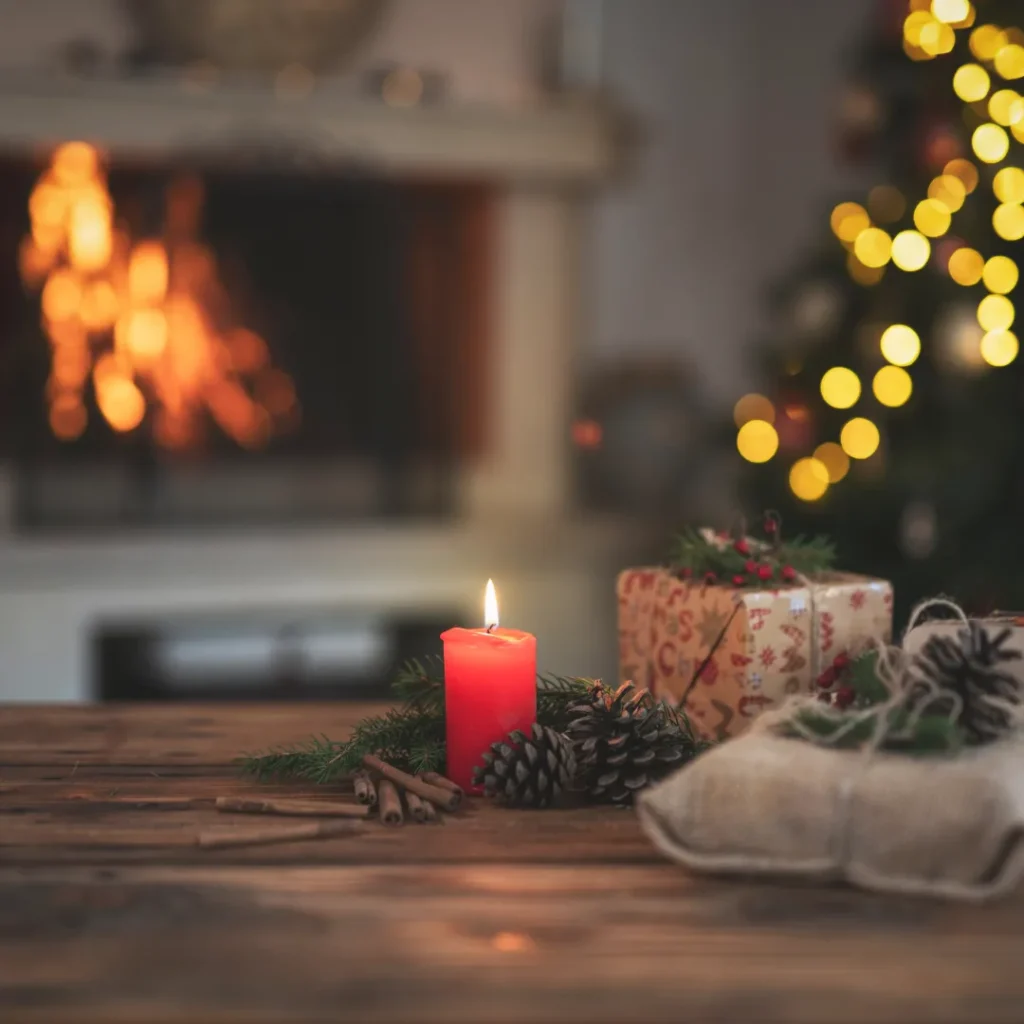 Κερί και χριστουγεννιάτικα δώρα πάνω σε ξύλινο τραπέζι που αποπνέουν θαλπωρή