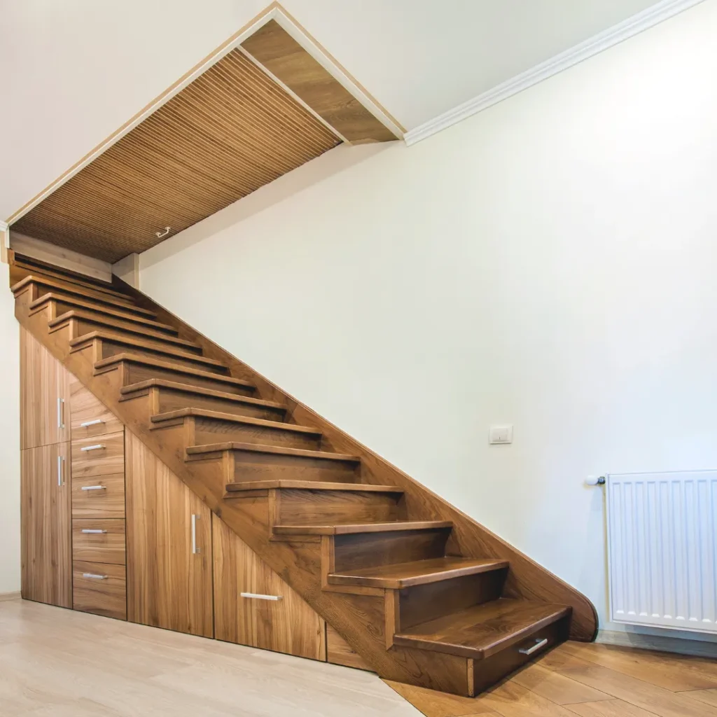 Custom ξύλινη κατασκευή με συρτάρια και ντουλάπια κάτω από εσωτερική σκάλα για πλήρη εκμετάλλευση του χώρου.